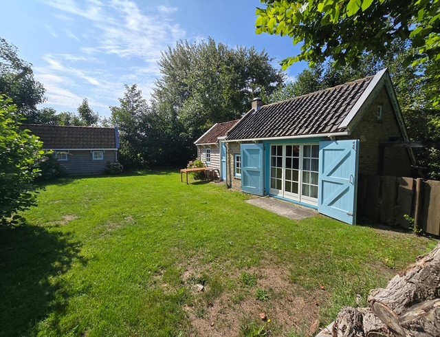 Het huisje met grasveld en bomen eromheen